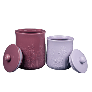 Two ceramic jars, one purple and one magenta, with floral patterns on a transparent background