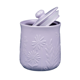 Purple ceramic jar with floral embossing and a lid on a colorless background