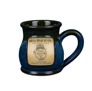 Blue ceramic mug with a gold label on a blue background