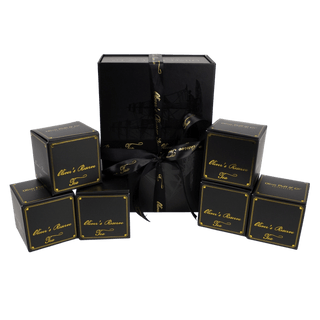 black gift box on white background tied with ribbon that reads 'oliver's reserve'. 6 small black boxes surround it