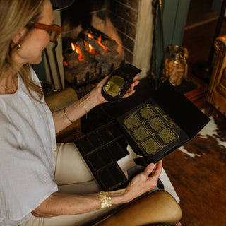 woman sitting in front of fireplace opening gift set