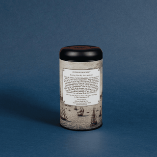 Cylindrical tea canister with decorative label on a blue background