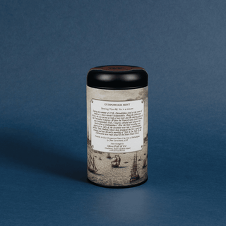 Cylindrical container with a black lid and decorative label on a blue background