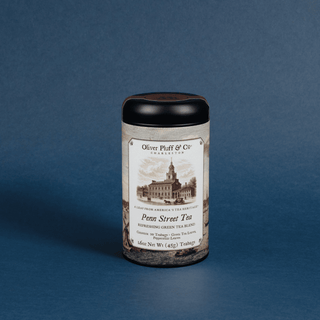 tea canister with black lid and historic label that reads 'penn street tea' on blue background
