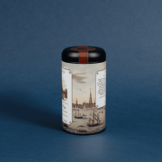Cylindrical tea canister with decorative label on a blue background