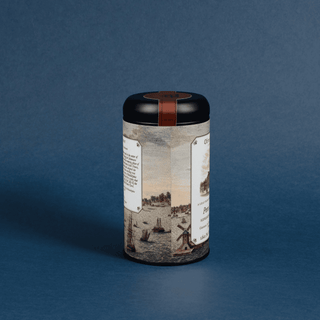 tea canister with black lid on blue background; label depicts a riverside scene