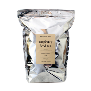 Silver tea bag packaging with a label for raspberry iced tea on a white background