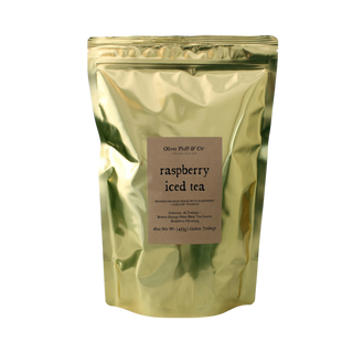 Gold packaging of raspberry iced tea with a label on a white background