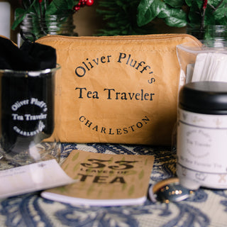 Tea travel set with 'Oliver Pluff's Tea Traveler' branding on a patterned surface.