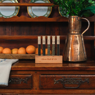 Wooden dresser with a copper pitcher, flowers, and a wooden box on top