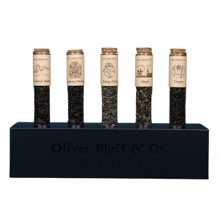 5 tubes of green or black tea with labels in black rectangular stand