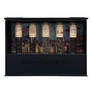 5 tubes of green or black tea with labels in black rectangular stand, inside a black gift box