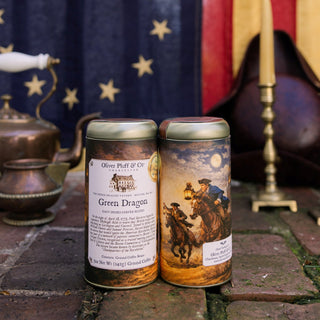 Two coffee tins with labels in front of a flag