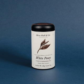 Tea canister labeled 'White Peony' by Oliver Pluff & Co on a blue background