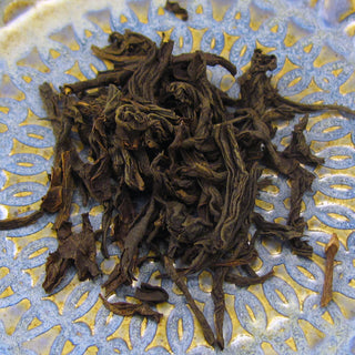 loose leaf tea in pile on blue and yellow plate