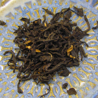 pile of loose leaf tea on blue and yellow plate