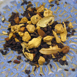 pile of yellow and dark Masala chai loose leaf tea on blue plate