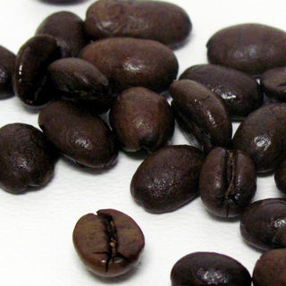 hand full of black whole coffee beans