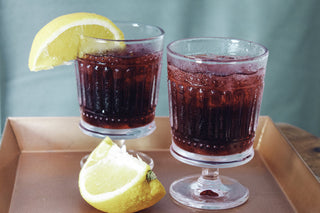 two glasses of ice tea with lemon slices on a bronze platter